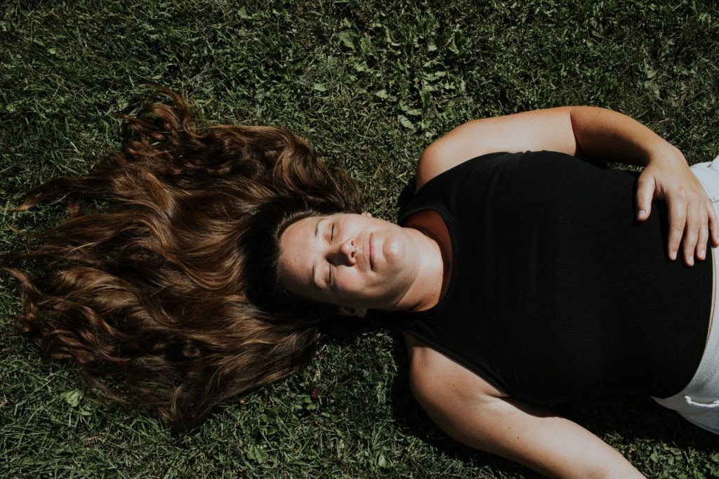 Eva en savasana - posture du yoga nidra - dans l'herbe